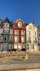 a large building with a fence in front of it at Duplex Léon - Villa Bon Accueil proche mer in Mers-les-Bains