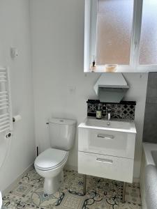 a white bathroom with a toilet and a sink at Escale Bretonne in Ploërmel +7 photos
