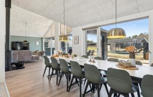 a dining room and living room with a large table and chairs at Pet Friendly Home In Nørre Nebel in Nørre Nebel