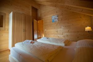 a bedroom with two beds in a wooden wall at Feriendorf Koralpe Chalet Edelweiss in St. Gertraud +32 photos