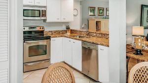 a kitchen with white cabinets and stainless steel appliances at Spacious 2BR condo on Siesta Key with private beach access in Siesta Key