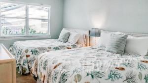 a bedroom with two beds and a window at Spacious 2BR condo on Siesta Key with private beach access in Siesta Key +27 photos