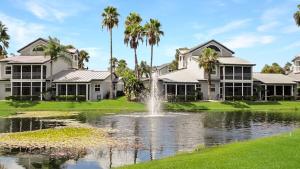 a house with a fountain in the middle of a pond at Spacious 2BR condo on Siesta Key with private beach access in Siesta Key