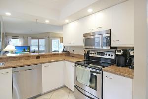 a kitchen with stainless steel appliances and white cabinets at Beach Access - Tennis - Two Pools - Fishing Dock in Siesta Key