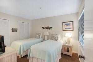 a bedroom with two beds and a tv in it at Spacious 2BR Siesta Key condo with private beach access in Siesta Key +34 photos