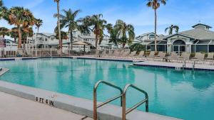 a large swimming pool with chairs and palm trees at Spacious 2BR Siesta Key condo with private beach access in Siesta Key