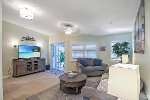 a living room with a couch and a tv at Updated 2BR Siesta Key condo with private beach access in Siesta Key