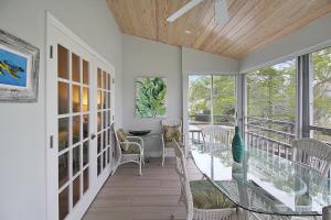 a room with a balcony with a table and chairs at 2nd floor lakeview condo In Siesta Key with private beach access in Siesta Key