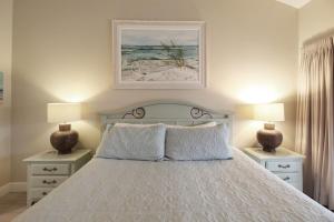 a bedroom with a bed with two nightstands and two lamps at 2nd floor lakeview condo In Siesta Key with private beach access in Siesta Key +36 photos