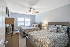a bedroom with two beds and a ceiling fan at Updated 2BR Siesta Key condo with private beach access in Siesta Key +40 photos