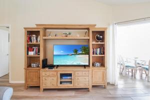a television in a wooden entertainment center in a living room at Spacious 3BR Siesta Key condo with private beach access in Siesta Key