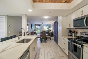 een keuken met een spoelbak en een fornuis bovenste oven bij Lakefront Siesta Key condo with private beach access in Siesta Key