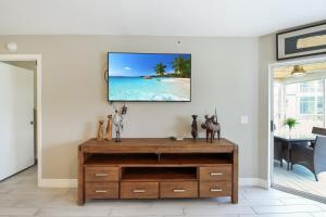 een woonkamer met een tv aan de muur bij Lakefront Siesta Key condo with private beach access in Siesta Key