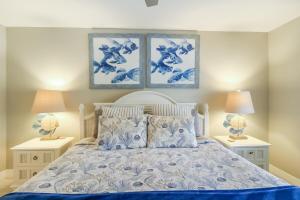 een slaapkamer met een blauw en wit bed met 2 lampen bij Lakefront Siesta Key condo with private beach access in Siesta Key +30 foto's