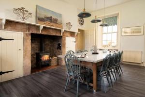 a dining room with a table and chairs and a fireplace at East House in Berwick-Upon-Tweed