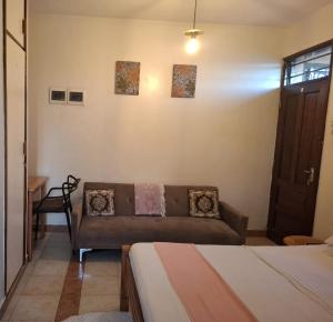 a living room with a couch and two beds at Studio Apartment, Nyali Mombasa in Mombasa