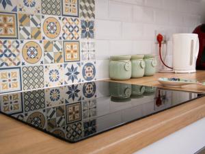 a kitchen with a counter with tiles on the wall at Seashells in Bridlington +32 photos
