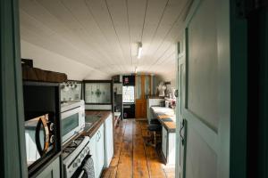 a kitchen with white appliances and a wooden floor at Swallowfield Glamping-The Last Stop in Yeovil