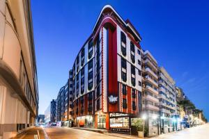 a red building on a city street at night at Hay Hotel Alsancak in Izmir