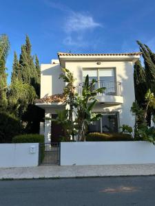 a white house with a fence in front of it at LC Palm Villa in Protaras