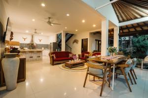 uma cozinha e sala de estar com mesa e cadeiras em Sari Temuku Villa em Seminyak