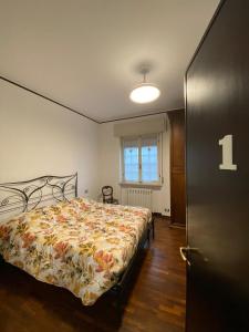a bedroom with a bed with a floral bedspread at Villa Baraggioli in Galliate +37 photos