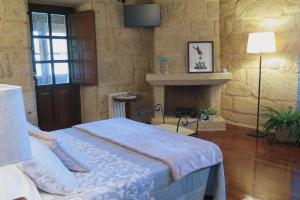 a bedroom with a bed and a fireplace at Pazo Carballo Hotel in Sampaio