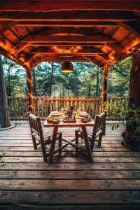 a wooden table and chairs on a wooden deck at ALPINEST - Les Cabanes du Pas de la Louve in Serres