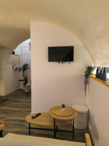 a living room with a table and a tv on a wall at Ma douce Fenière in Saint-Rémy-de-Chargnat +26 photos