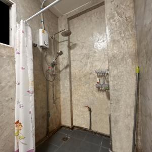 eine Dusche mit Duschvorhang im Bad in der Unterkunft 소다호스텔 Soda Hostel in Chiang Mai