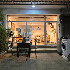 ein Wohnzimmer mit einem Tisch und ein Esszimmer in der Unterkunft 소다호스텔 Soda Hostel in Chiang Mai