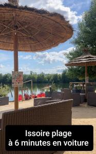 an image of an outdoor patio with an umbrella at Ma douce Fenière in Saint-Rémy-de-Chargnat