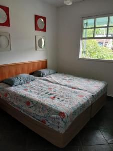 a bedroom with a bed in a room with a window at Paraíso de Verão - Disfrute final de semana em Casa Exclusiva com piscina, sinuca e churrasqueira Aluguel para temporada em Riviera de São Lourenço in Bertioga +54 photos