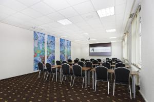 a conference room with tables and chairs and a screen at 4 Żywioły Falenty Ośrodek Konferencyjno-Szkoleniowy in Raszyn