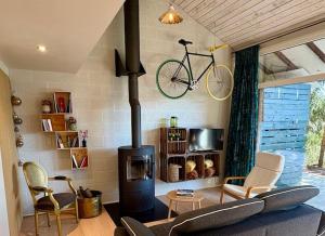a living room with a fireplace and a bike on the wall at Vieux Sart 34, chez Dame Béa in Stavelot