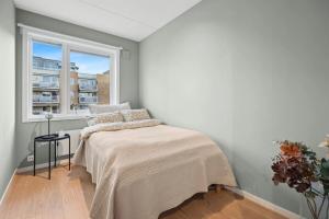 Un dormitorio con una cama y una ventana en Modern 3 bedroom apartment - 4 minute walk from metro - top floor baclony view, en Oslo