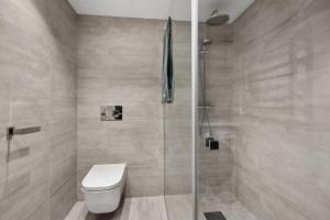 un baño con inodoro y ducha en Modern 3 bedroom apartment - 4 minute walk from metro - top floor baclony view, en Oslo