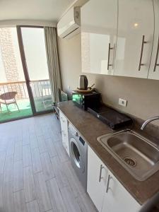 a kitchen with a sink and a washing machine at Bali studio in Hurghada