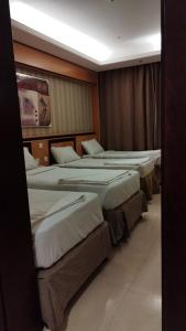 a row of beds in a hotel room at فندق الفجر البديع 5 in Jarwal