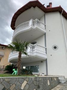 a white building with a balcony and a palm tree at SeaView Ground in Elevtheraí +3 photos