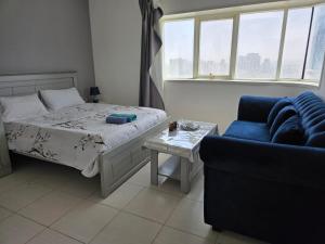 una camera da letto con un letto, un divano e un tavolo di Beachfront Room with Sea View ad Ajman