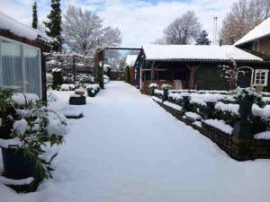 un patio cubierto de nieve junto a una casa en Florahof 1, en Eygelshoven 3 fotos más