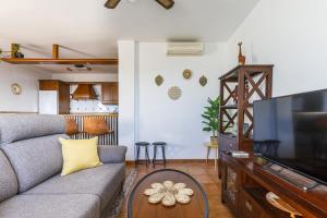 een woonkamer met een bank en een flatscreen-tv bij A&N Los Carmenes, Torre del Mar in Torre del Mar