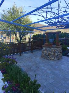 a stone patio with a pergola in a garden at La Casa Dei Desideri in Agerola