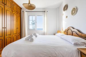 een slaapkamer met een groot wit bed met handdoeken erop bij A&N Los Carmenes, Torre del Mar in Torre del Mar
