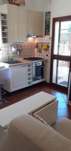 a kitchen with white cabinets and a stove top oven at Palma House in La Massimina-Casal Lumbroso