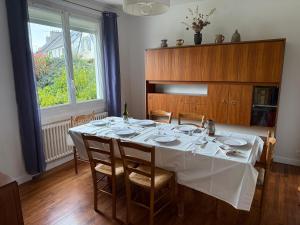 a dining room with a table with a white table cloth at Le castor - Quartier résidentiel in Saint-Brieuc