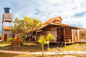 a small house with a lighthouse in front of it at Chalé Casal - Pousada Rancho Matos in Santo Amaro