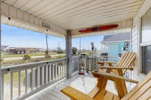 a deck with a bench and a surfboard on it at Macs Fish Camp in Dauphin Island