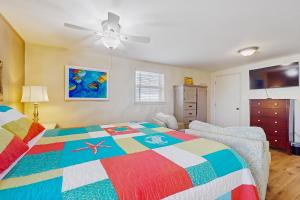a bedroom with a colorful bed and a ceiling fan at Macs Fish Camp in Dauphin Island